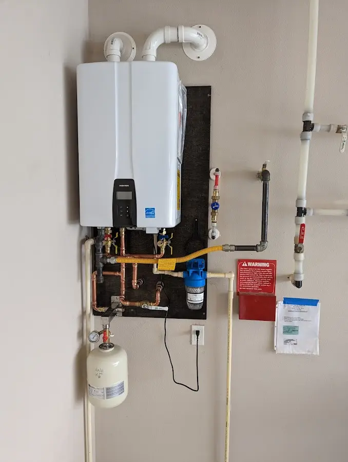 Professional plumber installing copper piping in a Fenton home